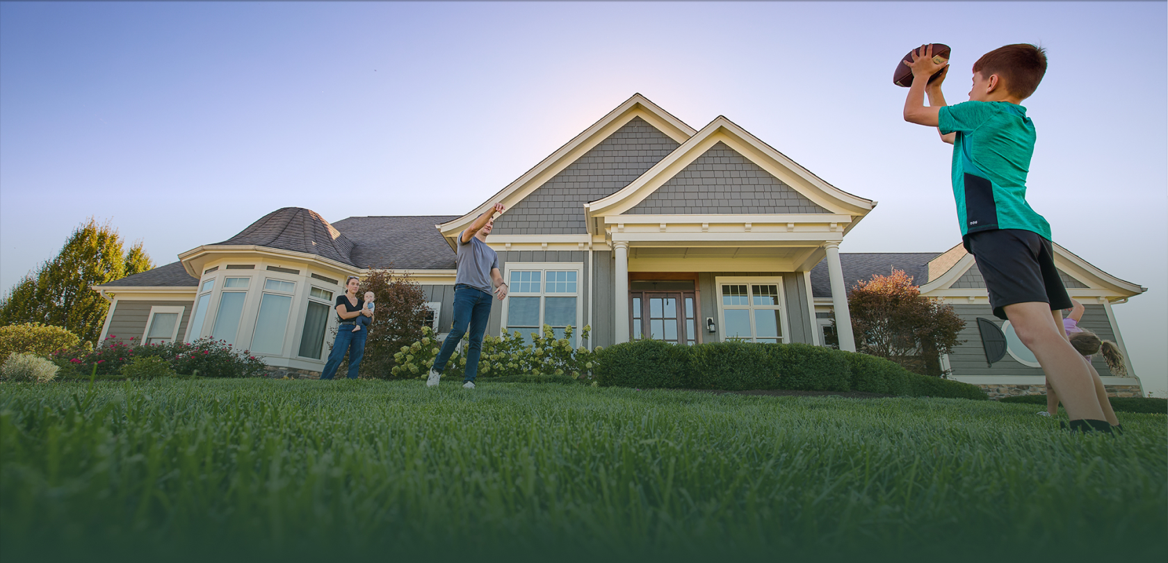 child playing on lawn in front of house