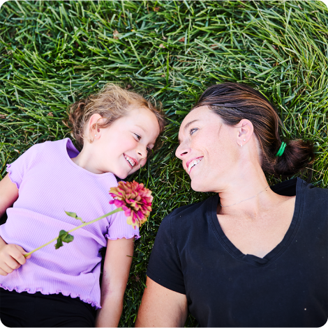 woman lying on grass with child